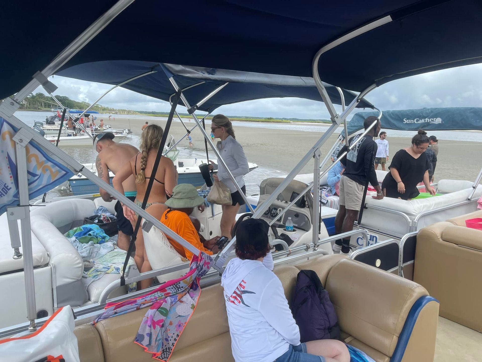 A group of people are sitting on a boat on the beach.