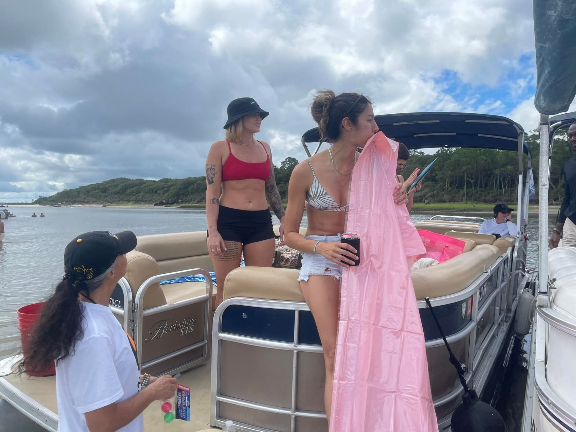 A group of women are standing on a pontoon boat.