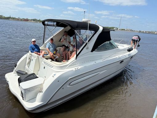 A group of people are sitting on a white boat in the water.