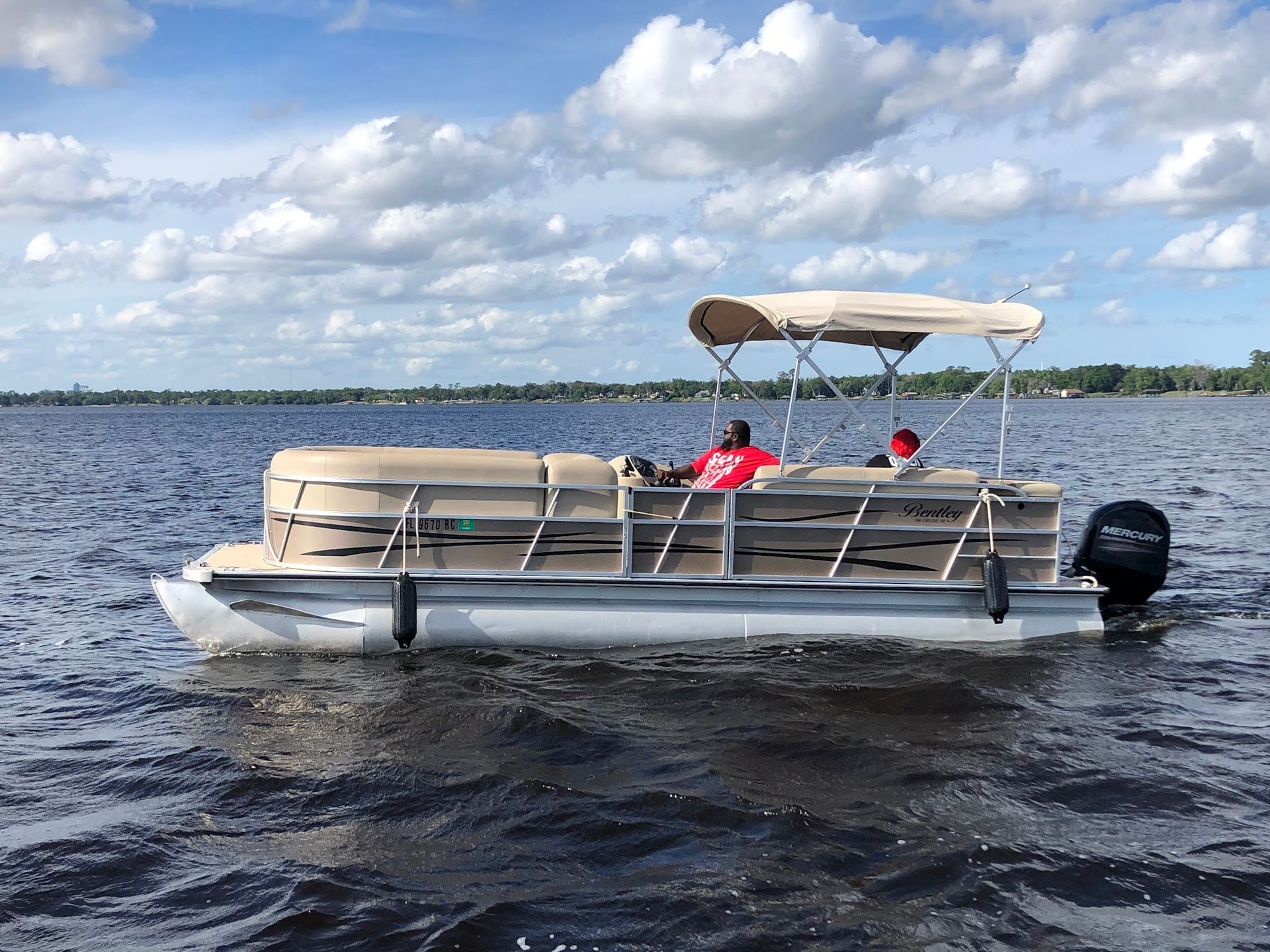 A pontoon boat is floating on top of a lake.