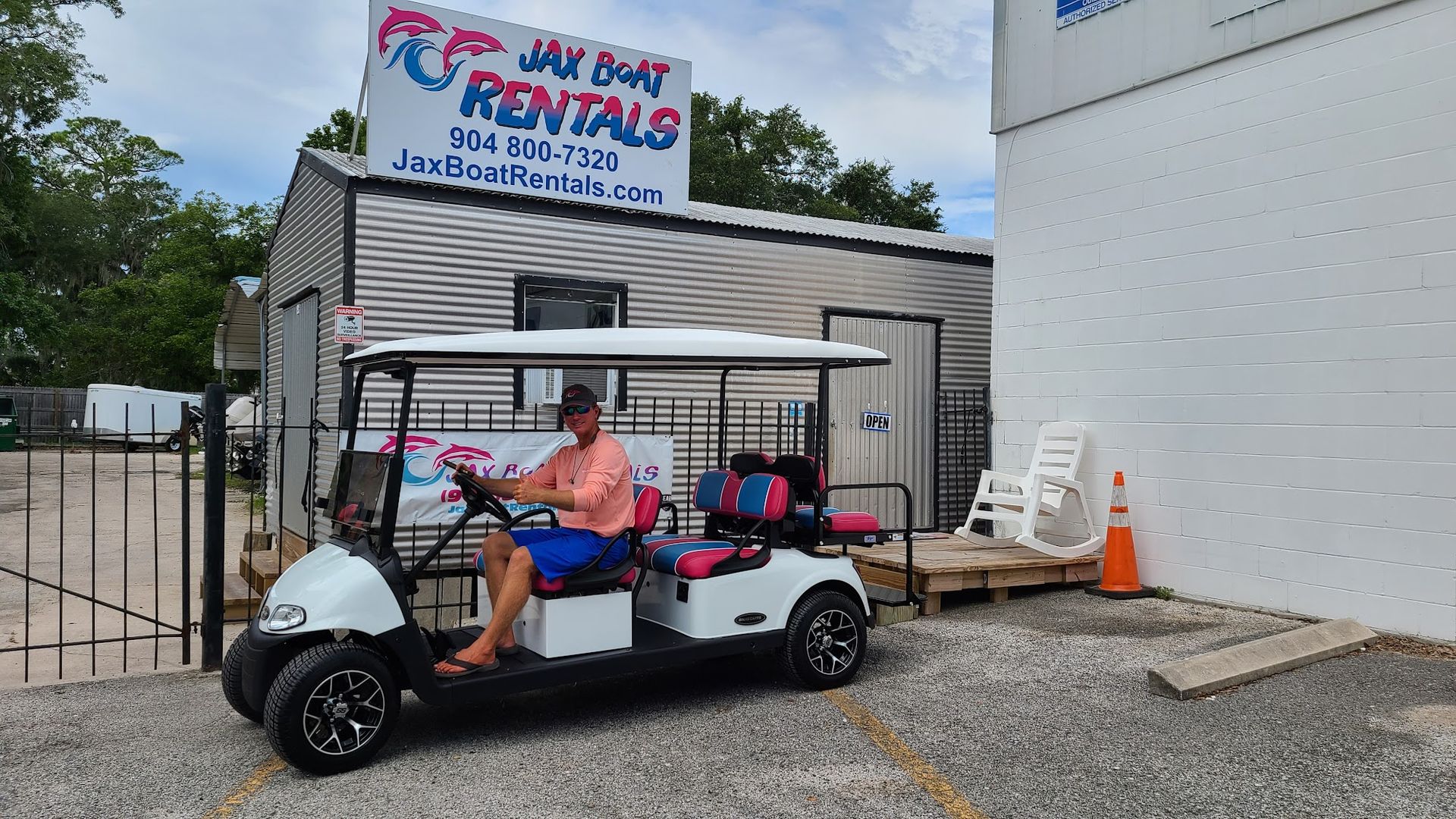 A man is sitting in a golf cart in front of a building.