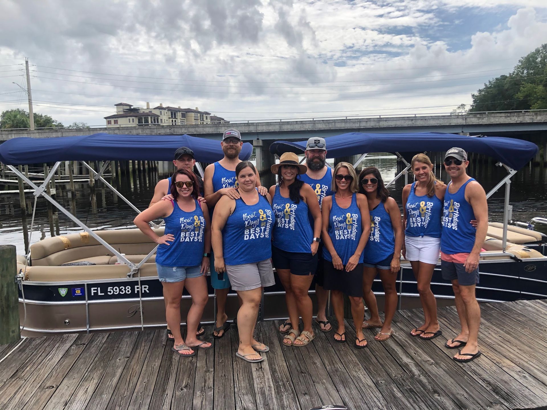 A group of people are posing for a picture in front of a pontoon boat.