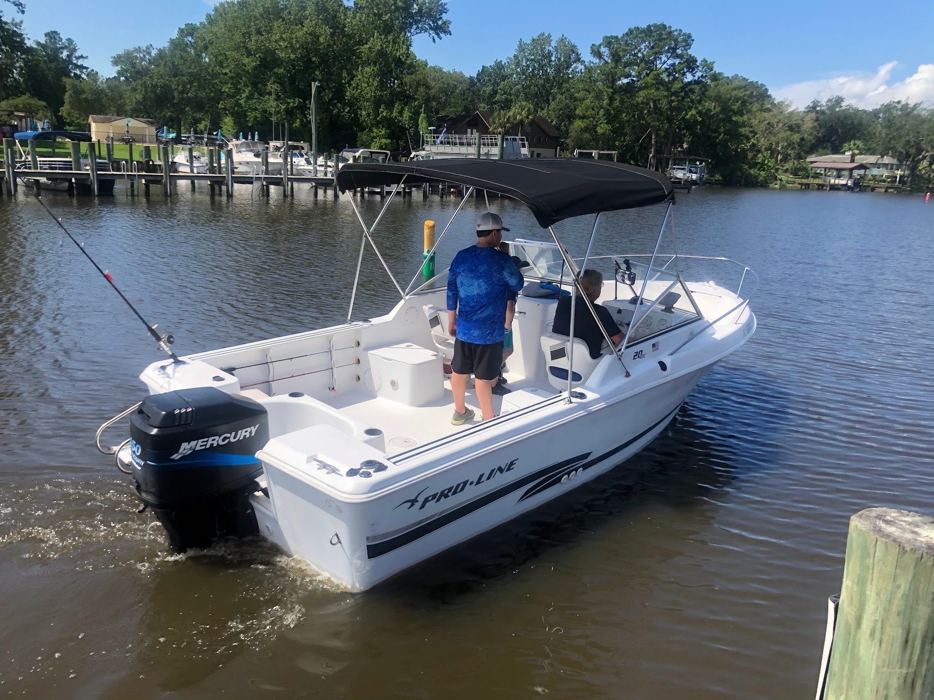 A man is standing on a boat in the water.