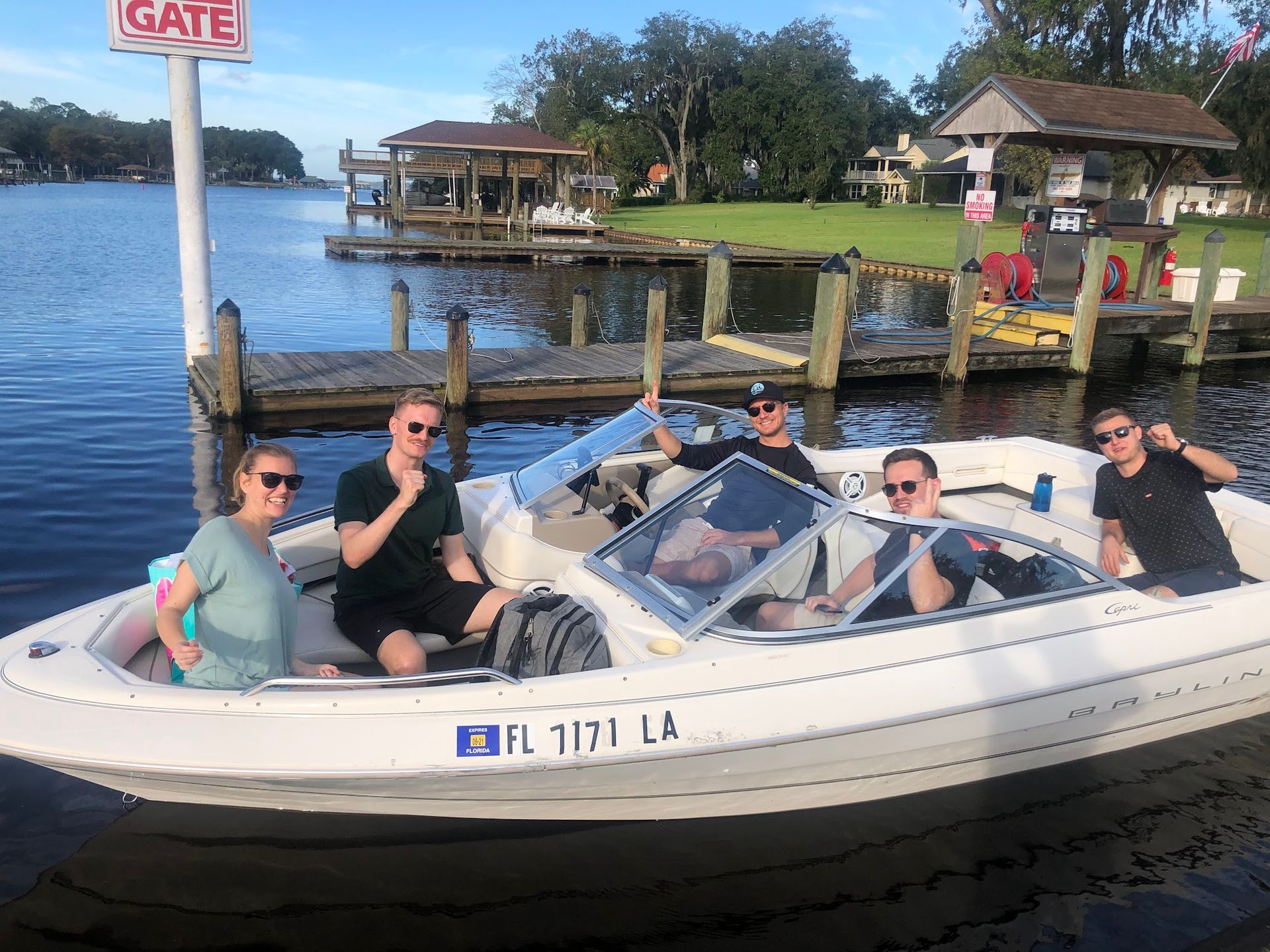 A group of men are sitting on the back of a boat.