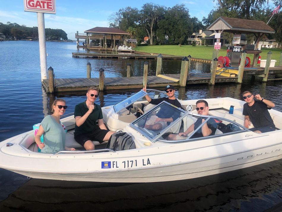 A group of men are sitting on the back of a boat.