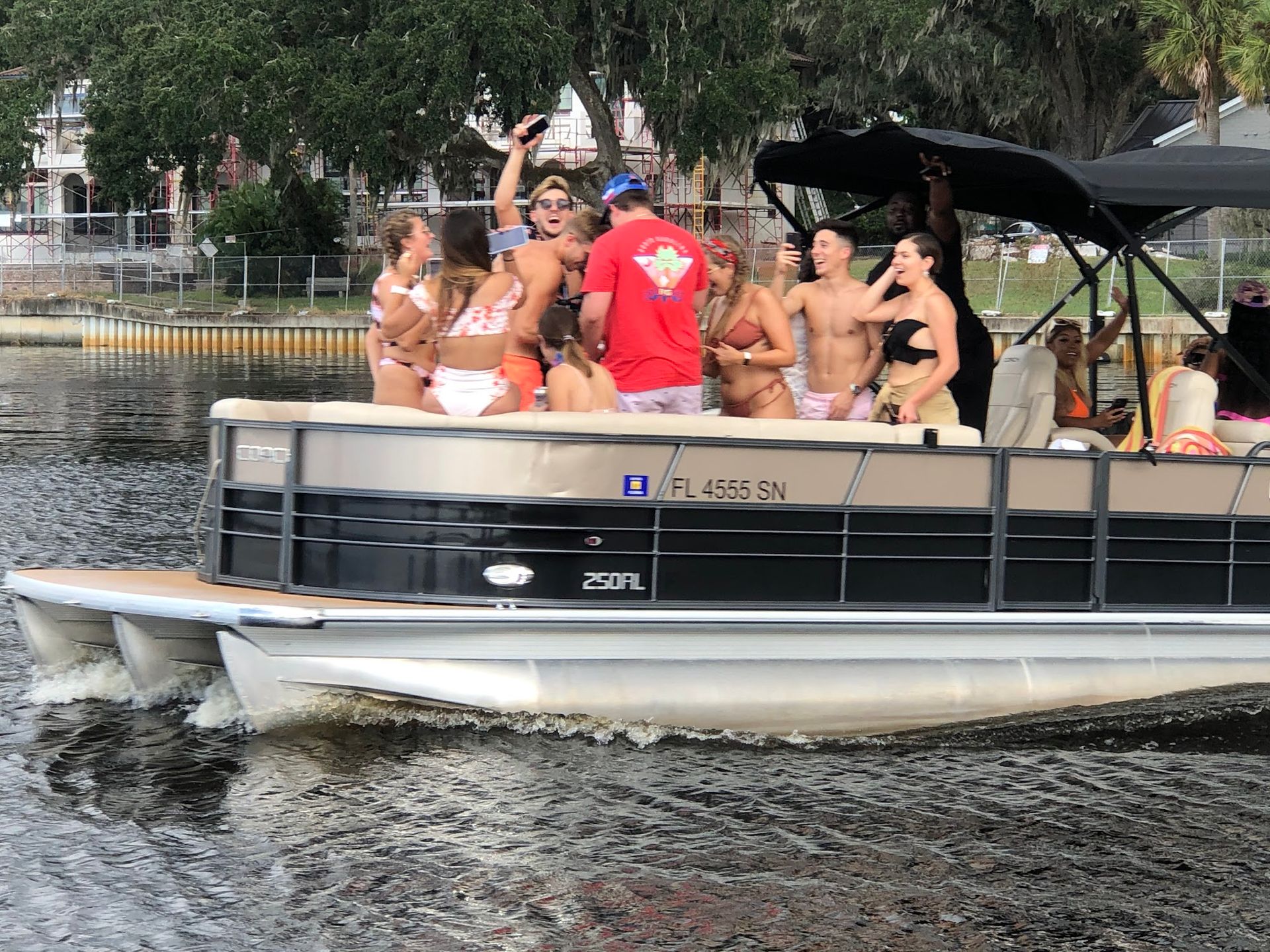A group of people are riding on a pontoon boat on a lake.