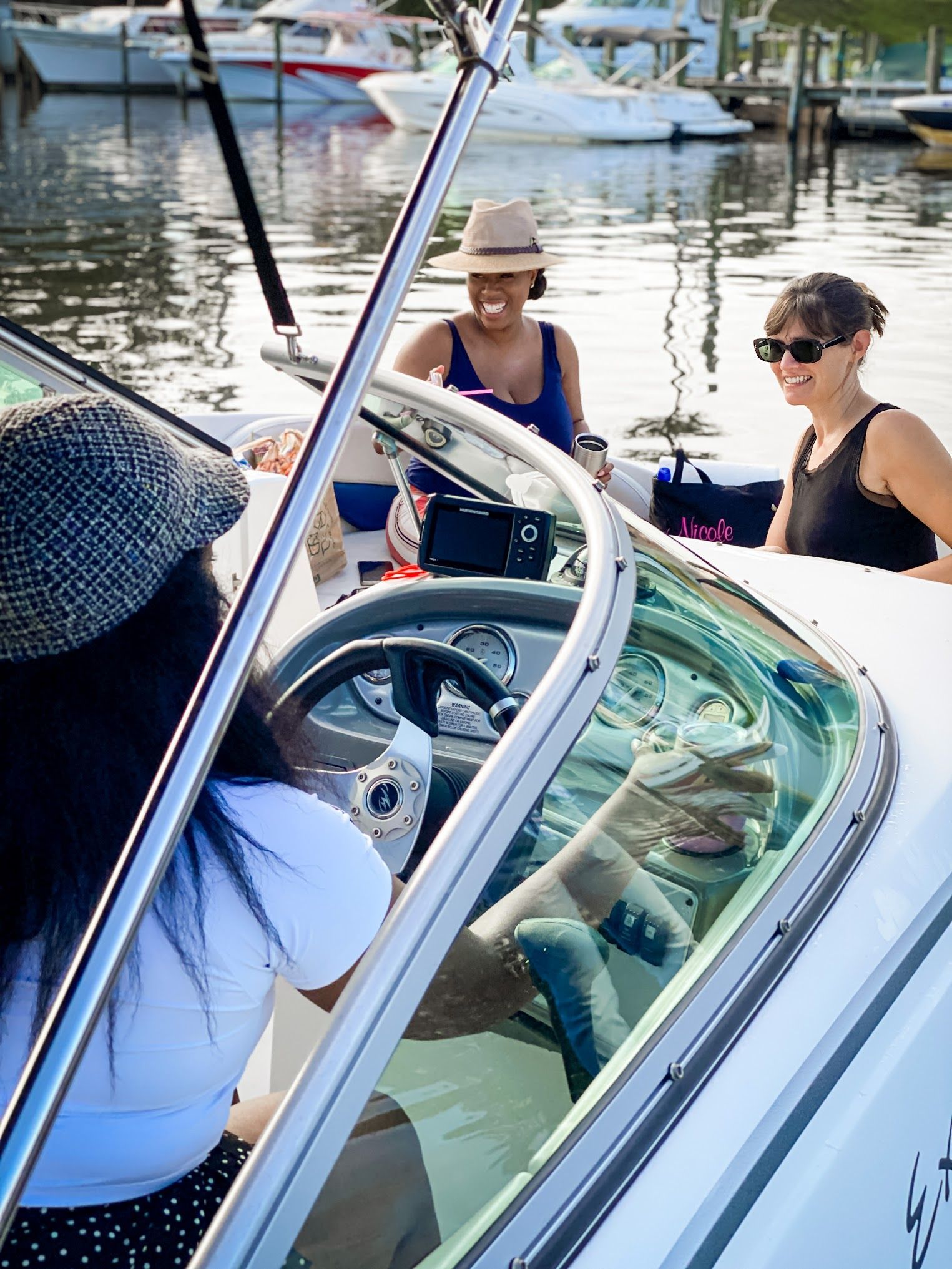 Two women are sitting on a boat in the water.