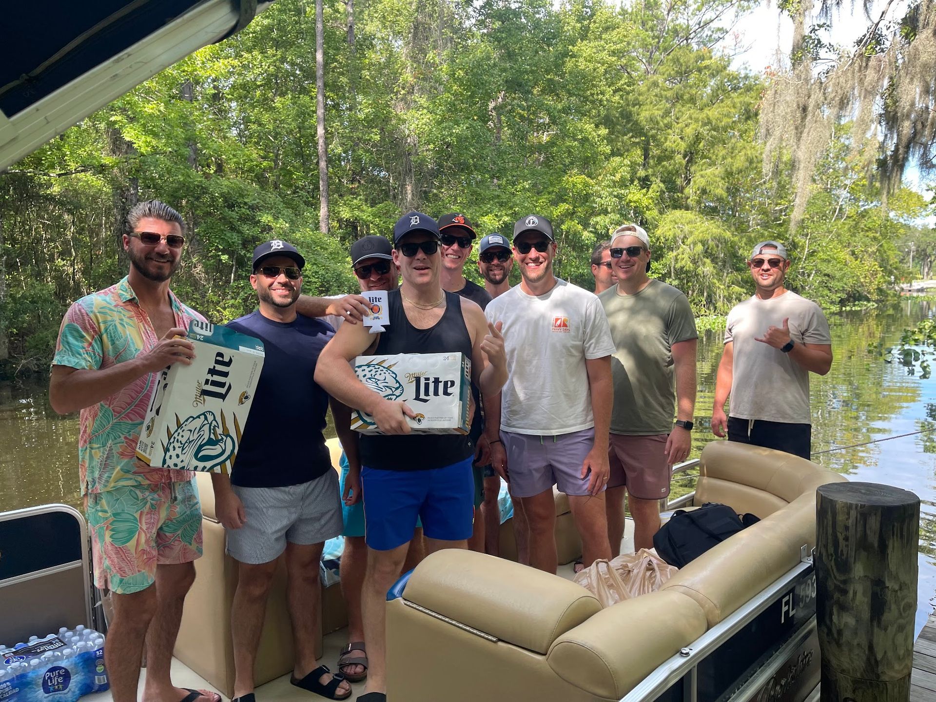 A group of men are posing for a picture on a pontoon boat.
