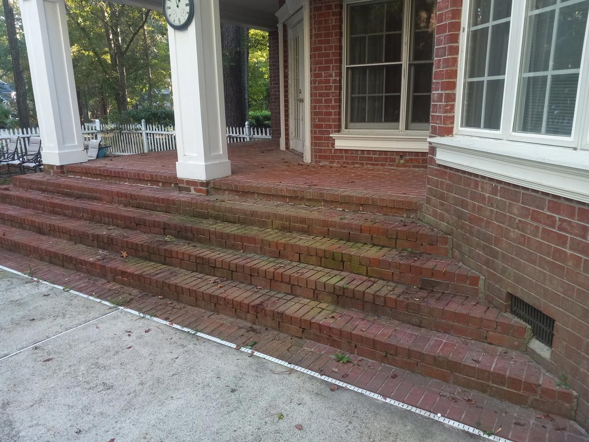 A brick porch with stairs leading up to it