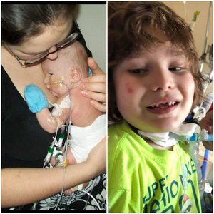 A woman is holding a baby next to a boy in a green shirt