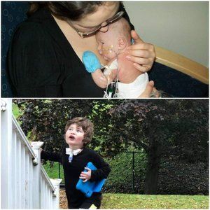 A woman holding a baby and a boy standing next to a fence