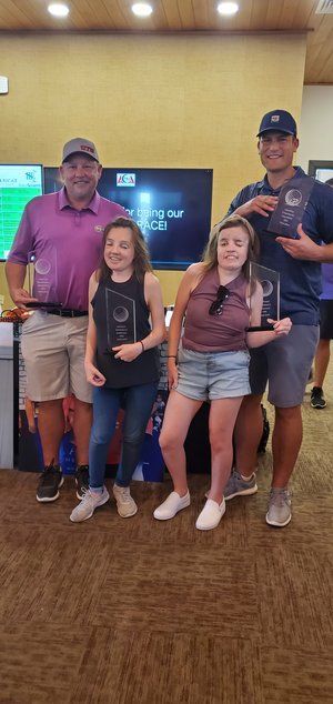 A group of people standing next to each other holding trophies.