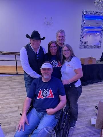 A group of people standing around a man in a wheelchair.