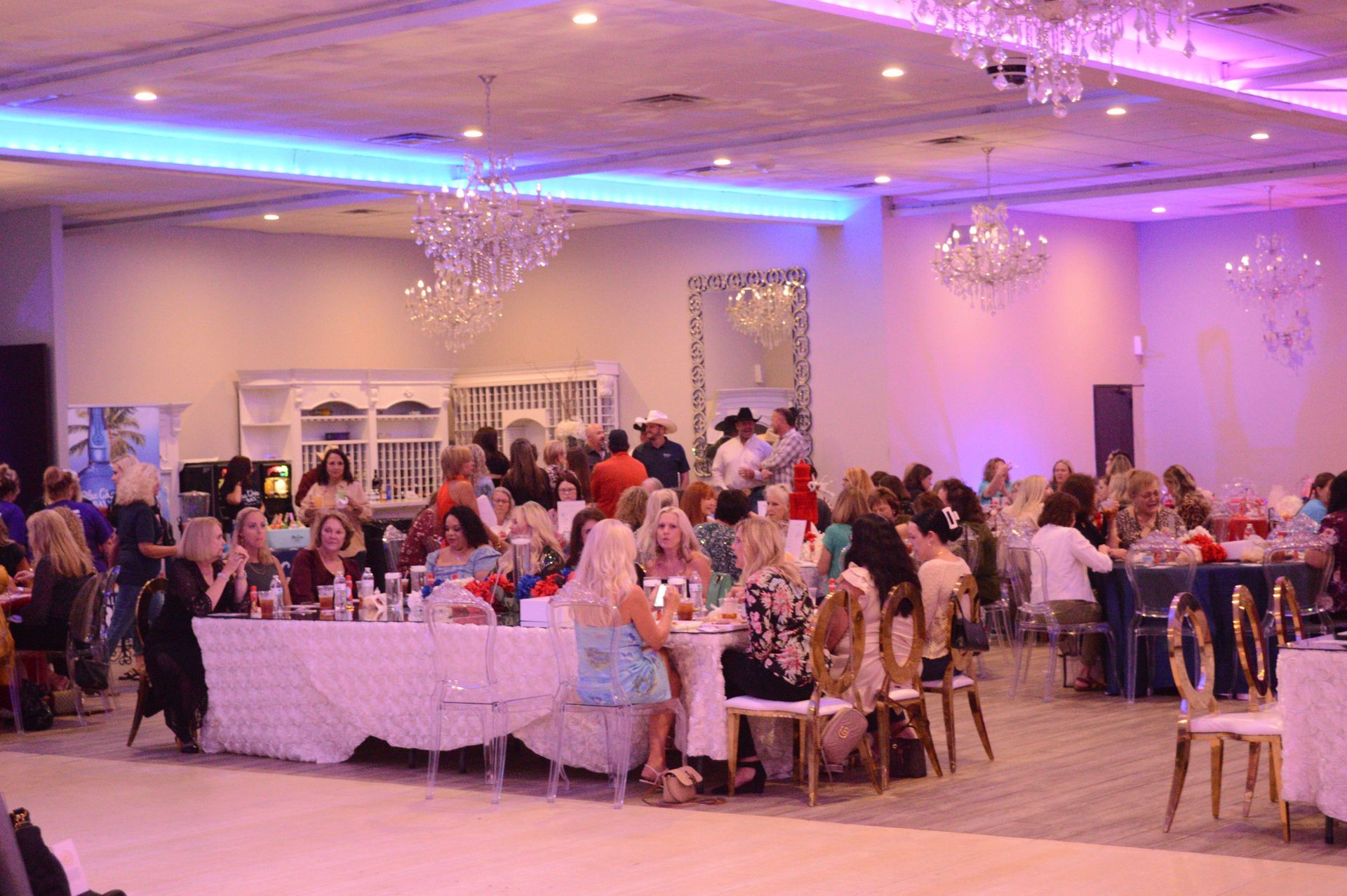 A large room filled with people sitting at tables and chairs.