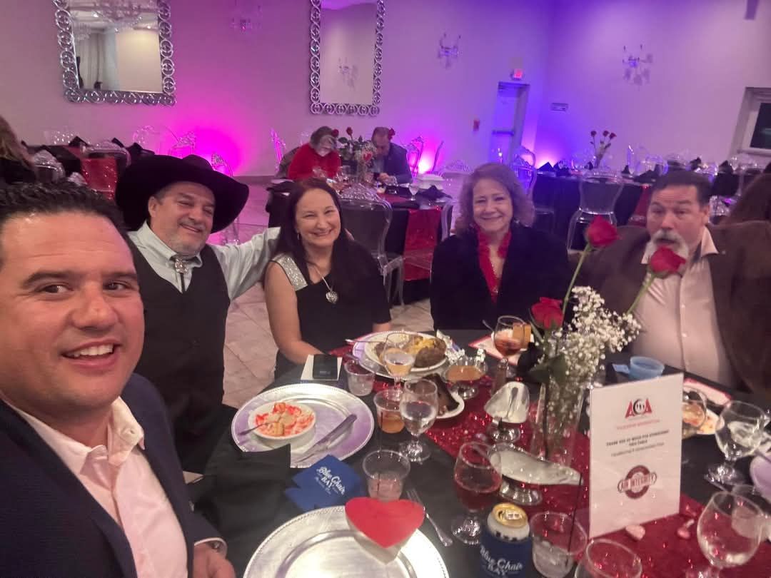 A group of people are sitting at a table with plates of food.