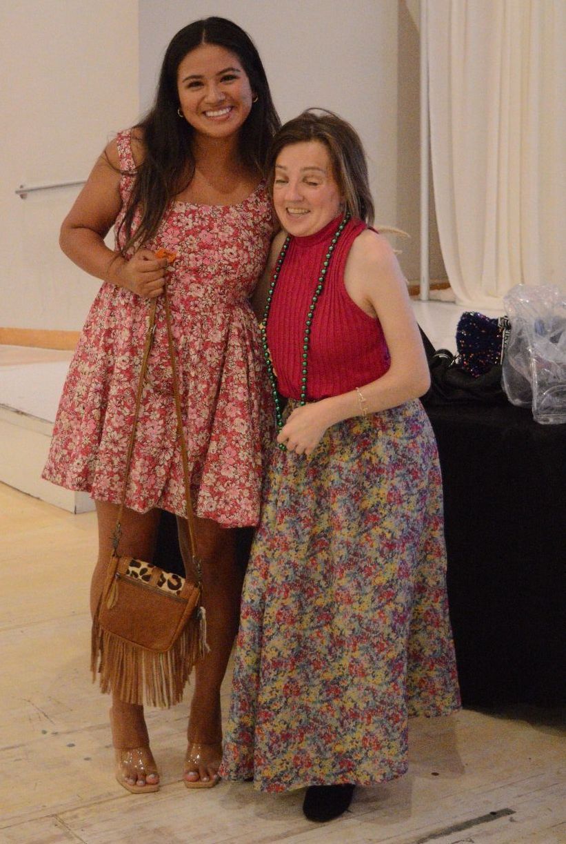 Two women are posing for a picture together in a room.