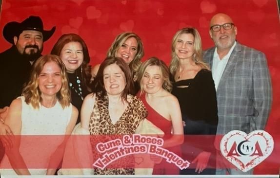 A group of people posing for a picture at a valentine 's banquet