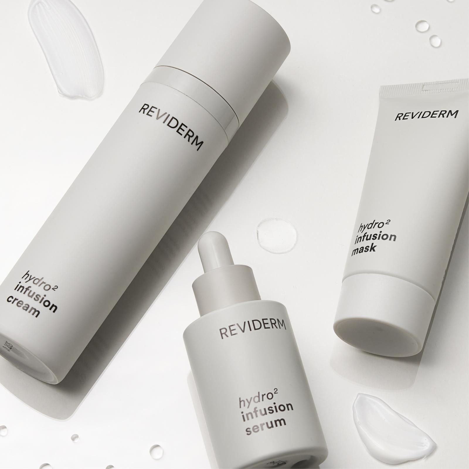 Drei Flaschen Reviderm-Produkte stehen auf einem Tisch