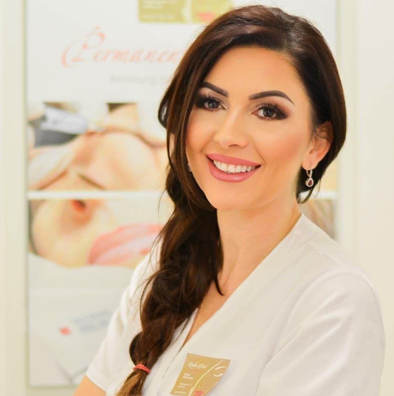 Eine Frau in einem schwarzen Hemd lächelt in die Kamera