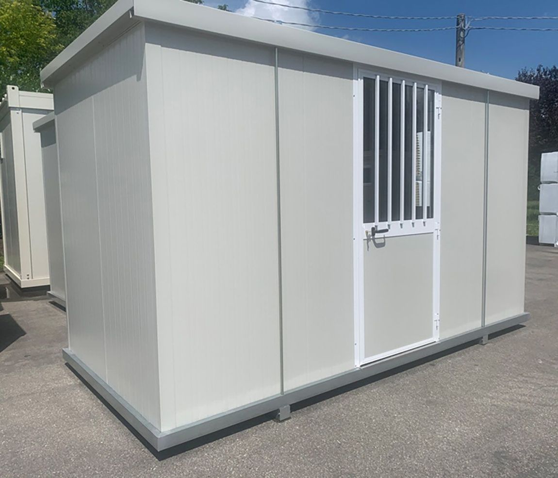 Cabina o unità di stoccaggio portatile in metallo grigio chiaro con una porta con cornice bianca e barre di sicurezza verticali.