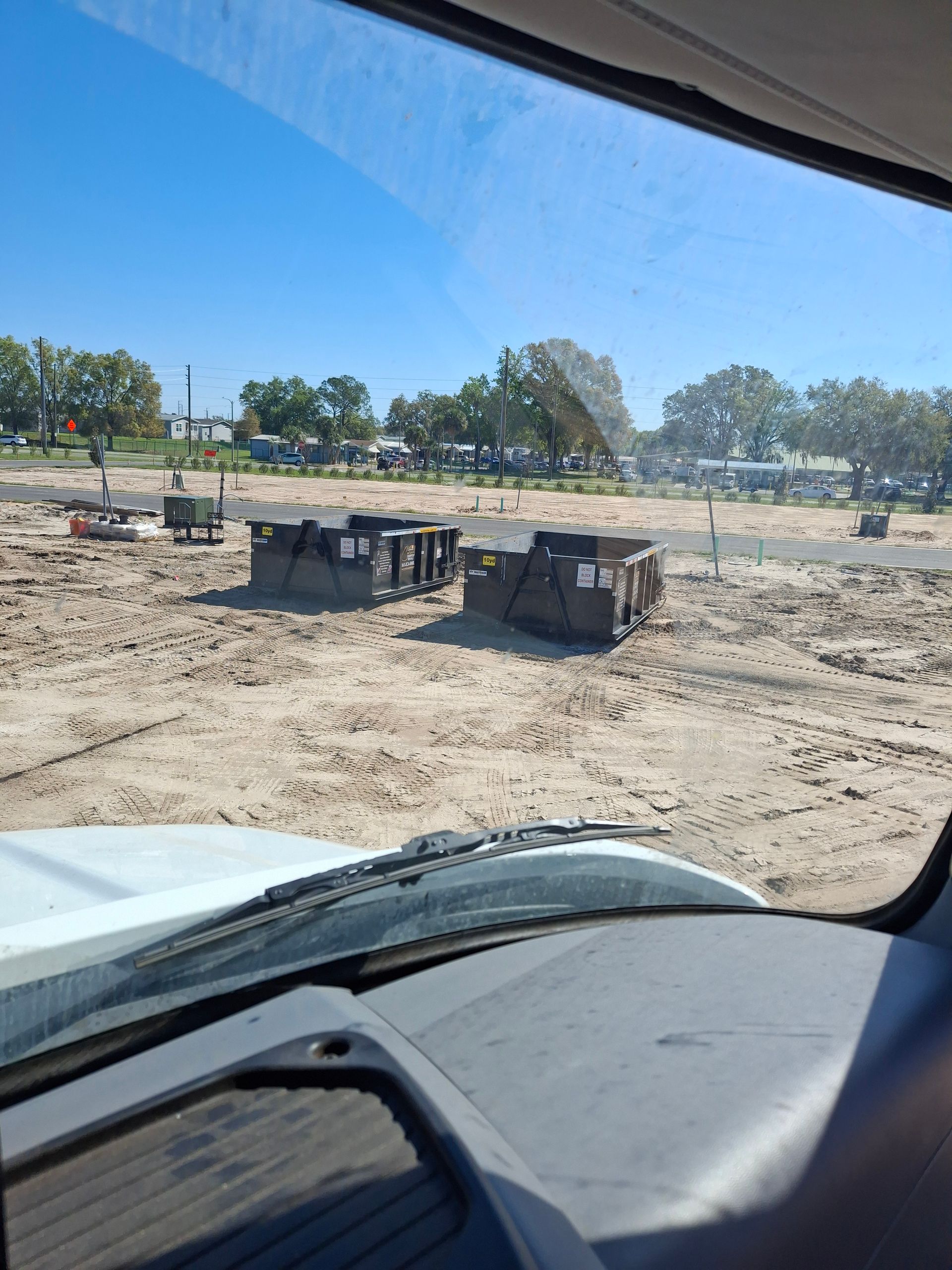 Two 10‑yard dumpsters at a construction site in Zephyrhills, Florida for dirt and clean concrete recycling.