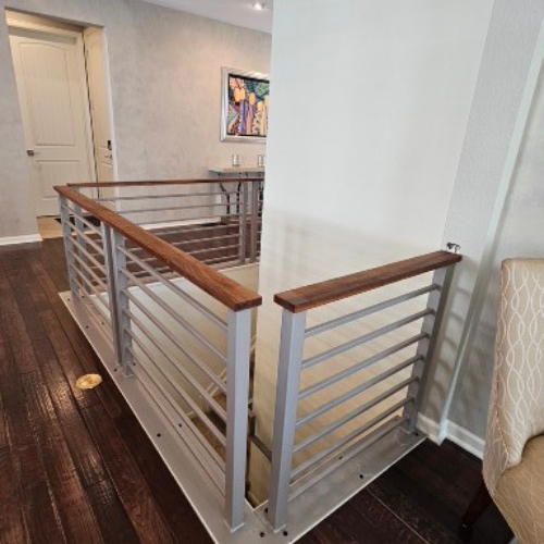 A staircase with a metal railing and wooden handrails