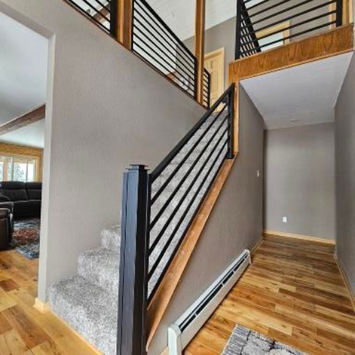 A staircase in a house with a black railing