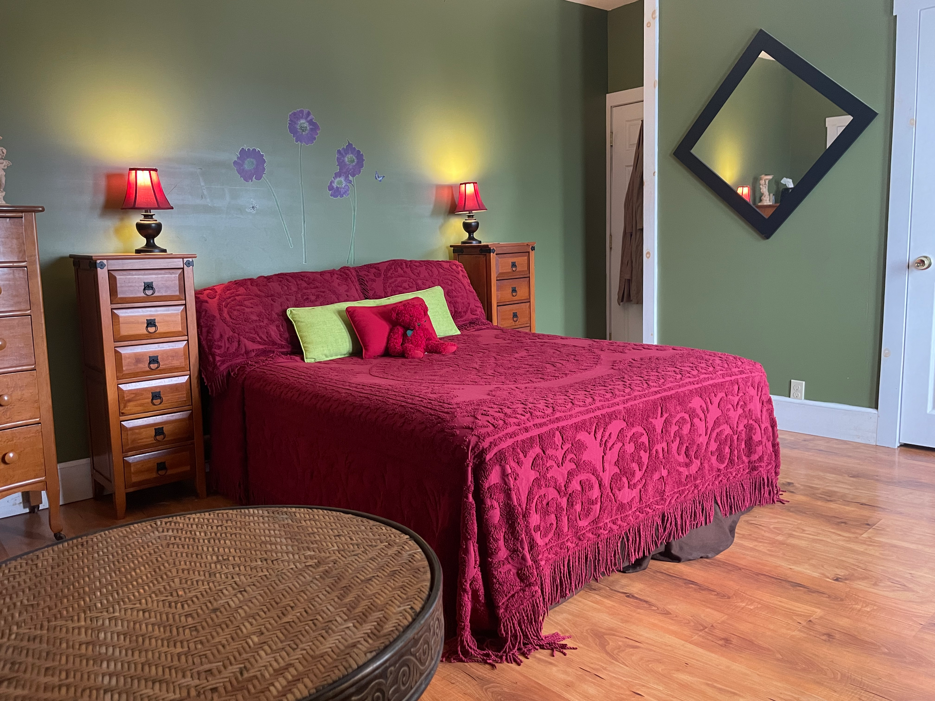 A bedroom with a red bed and green walls