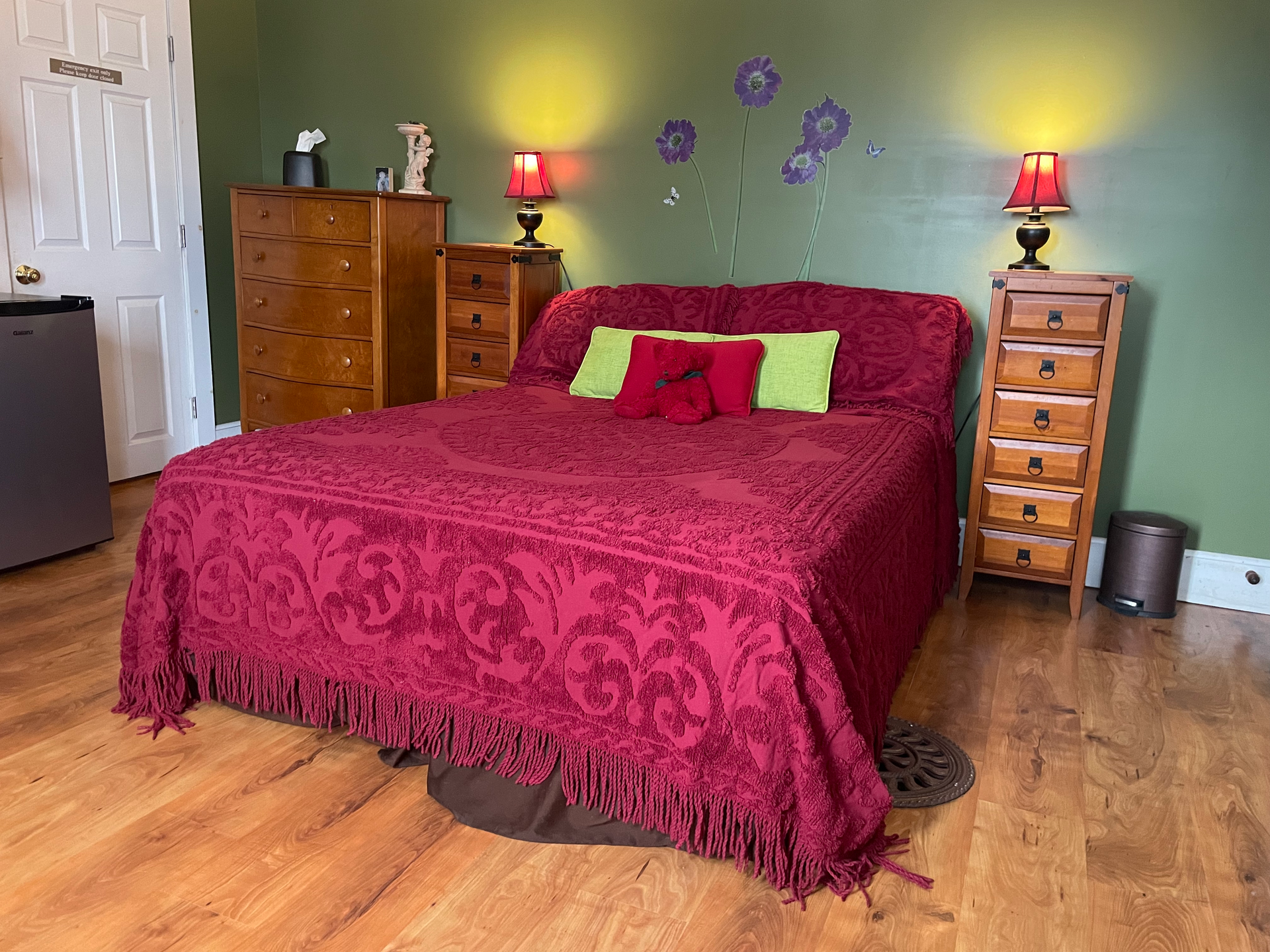 A bedroom with a bed , dresser , nightstand , and lamps.