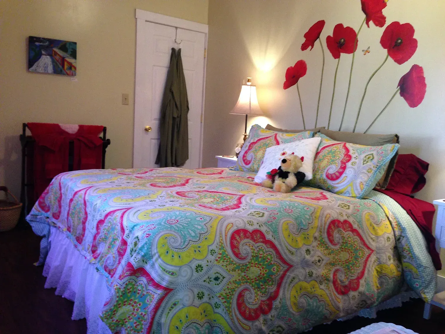 A bedroom with a bed and a teddy bear on it