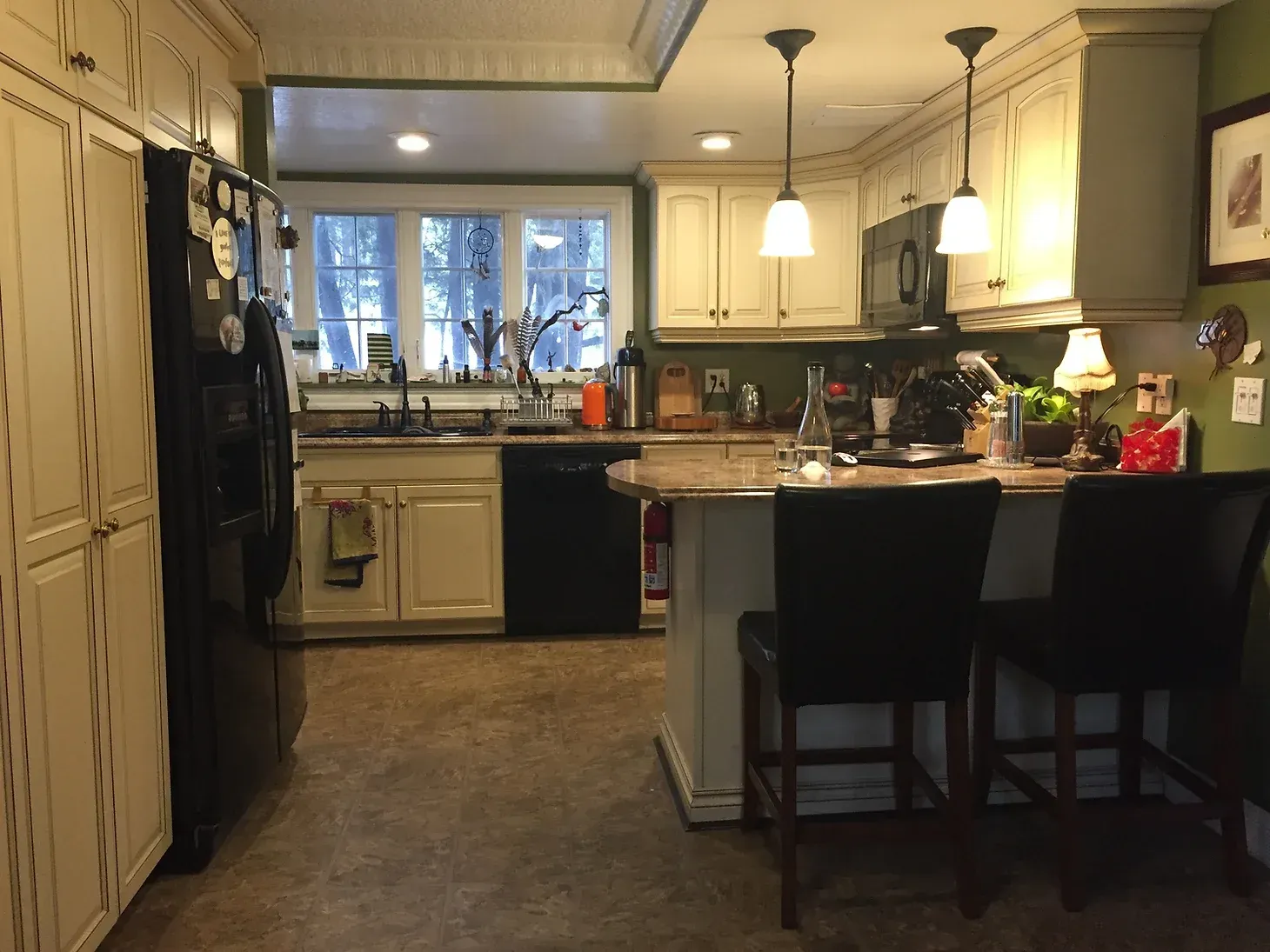 A kitchen with white cabinets and black appliances