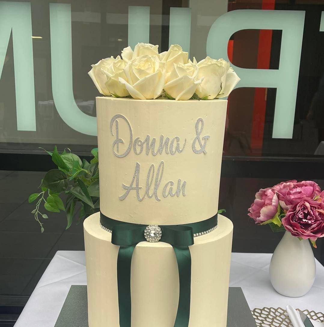 A wedding cake for donna and allan sits on a table