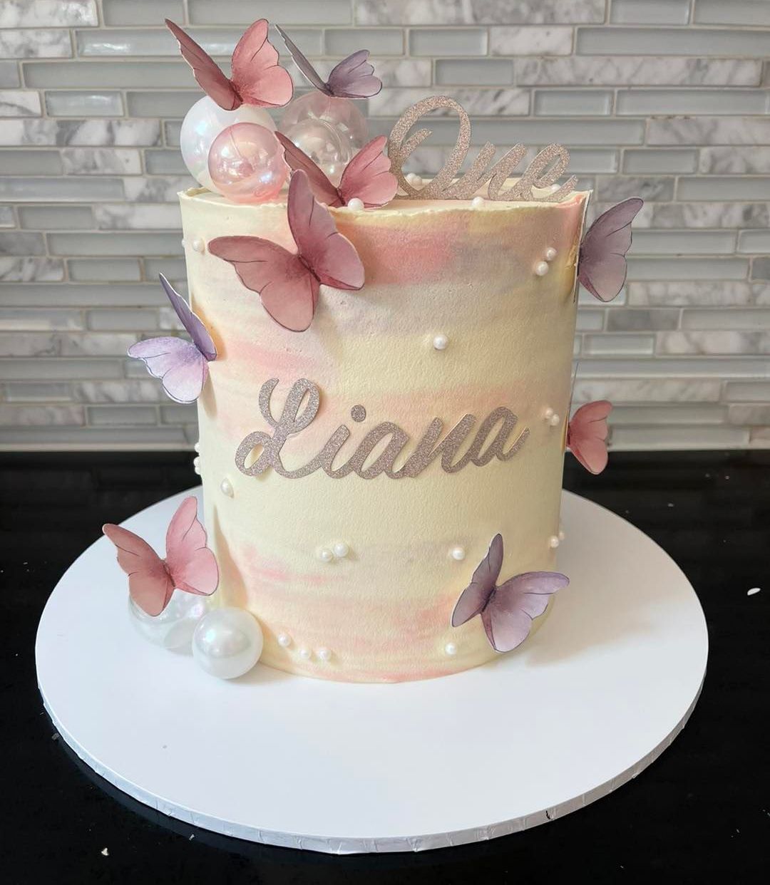 A cake with the name liava and butterflies on it