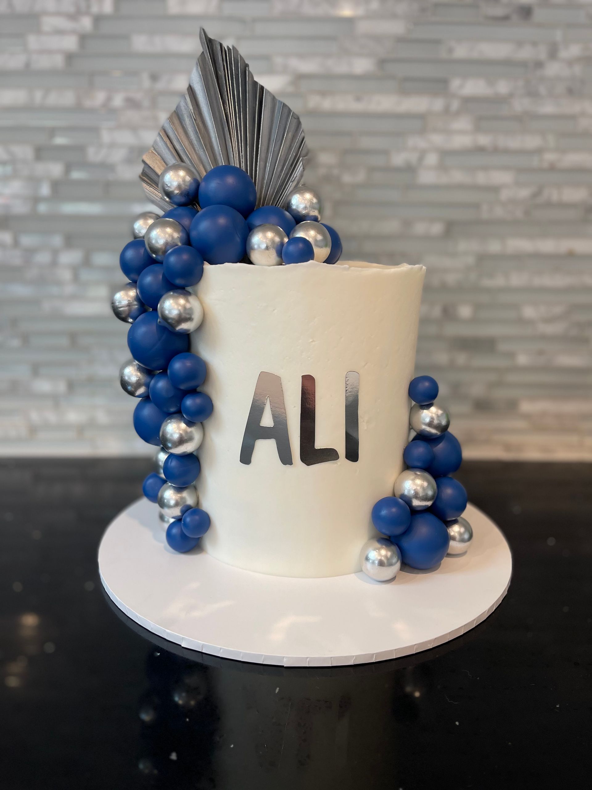 A white cake with the name ali on it