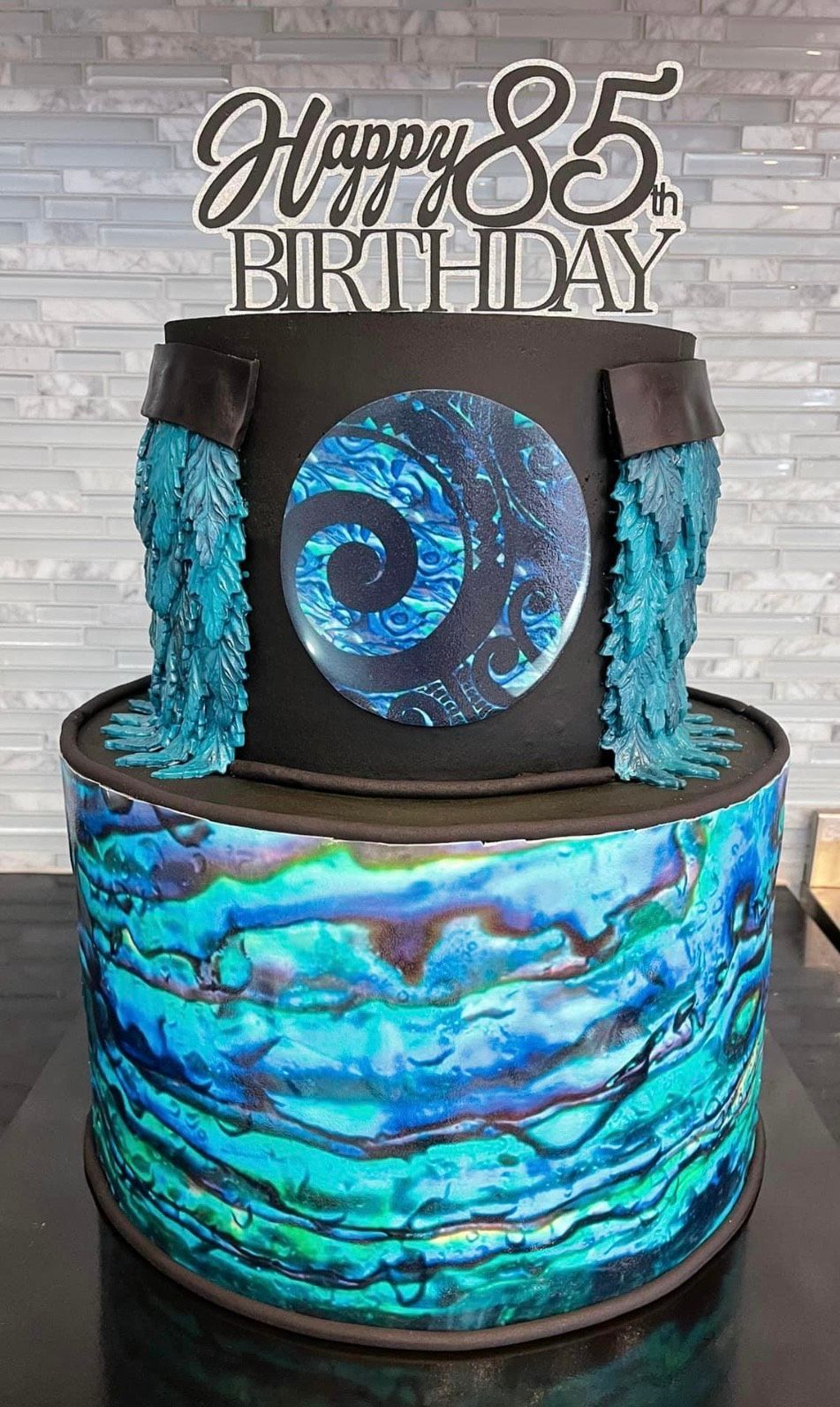 A birthday cake with a waterfall on top of it is on a table.