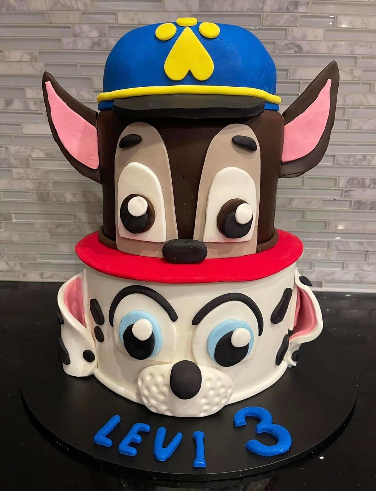 A cake with a dog on top that says levi 3