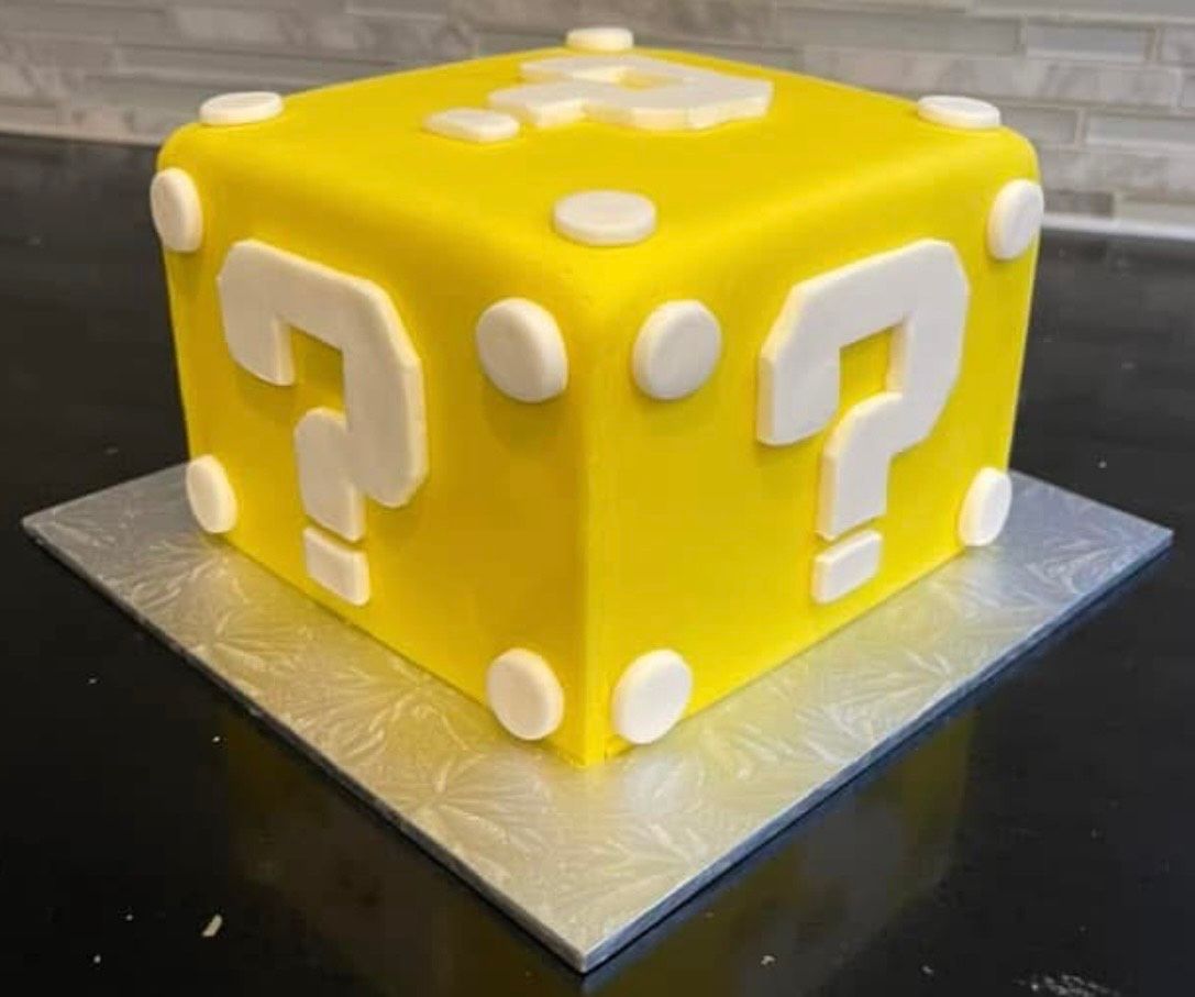 A yellow cube with white question marks on it