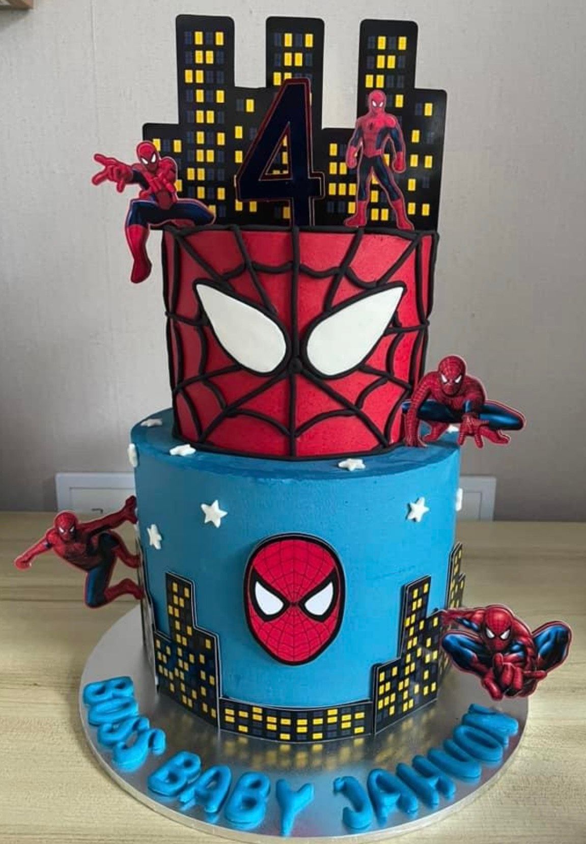 A blue and red cake with spider man on it