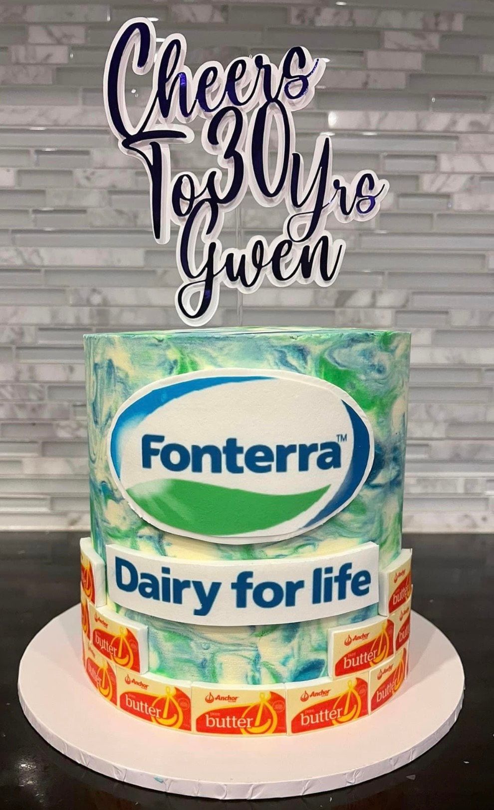 A birthday cake with a fonterra dairy for life logo on it.