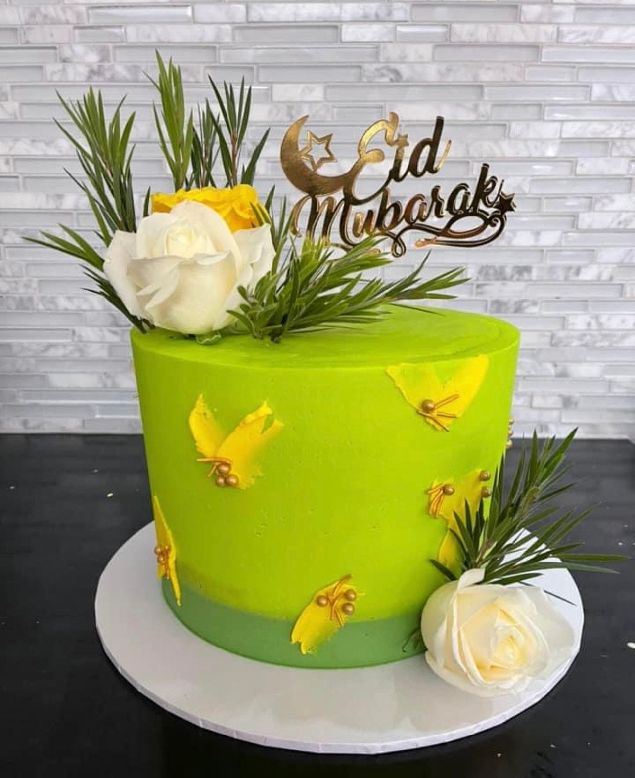 A green cake with yellow flowers and a topper on top of it.