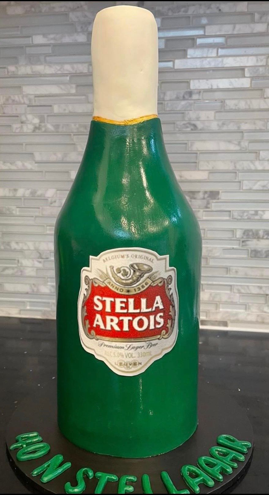 A cake in the shape of a stella artois bottle