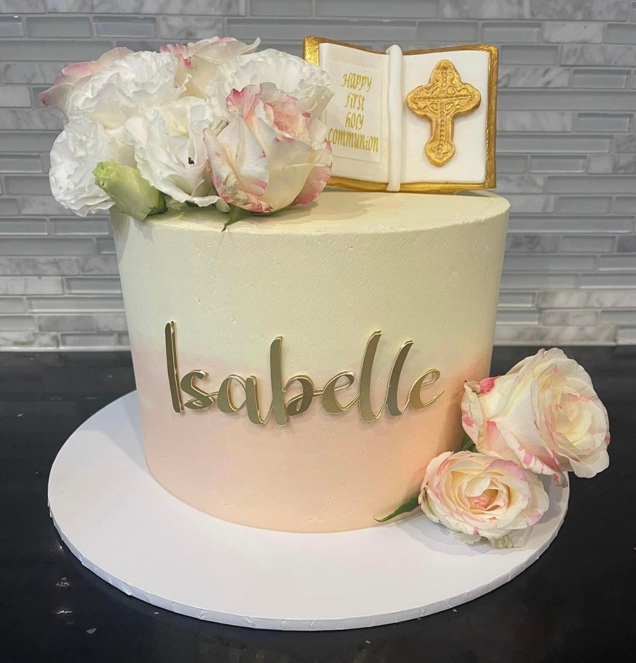 A cake with flowers and a cross on top of it.