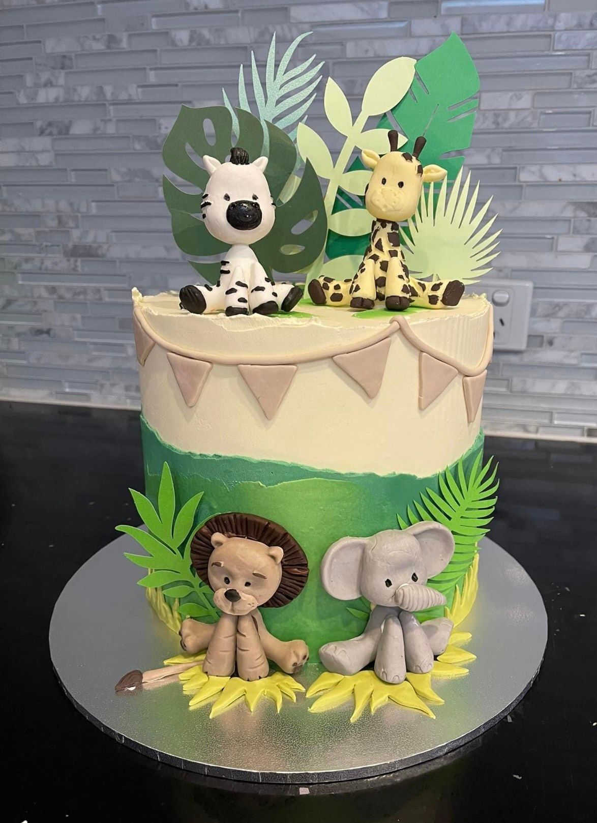 A cake with a zebra , giraffe , and elephant on top of it.