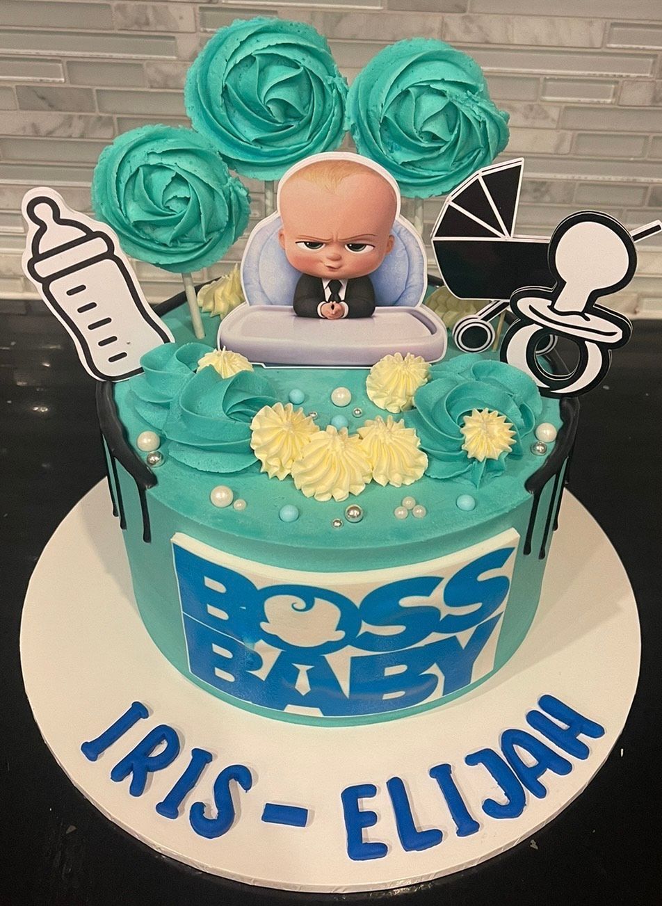 A blue and white cake with a baby on top of it.