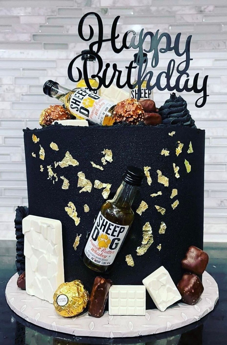 A birthday cake with a bottle of beer on top of it.