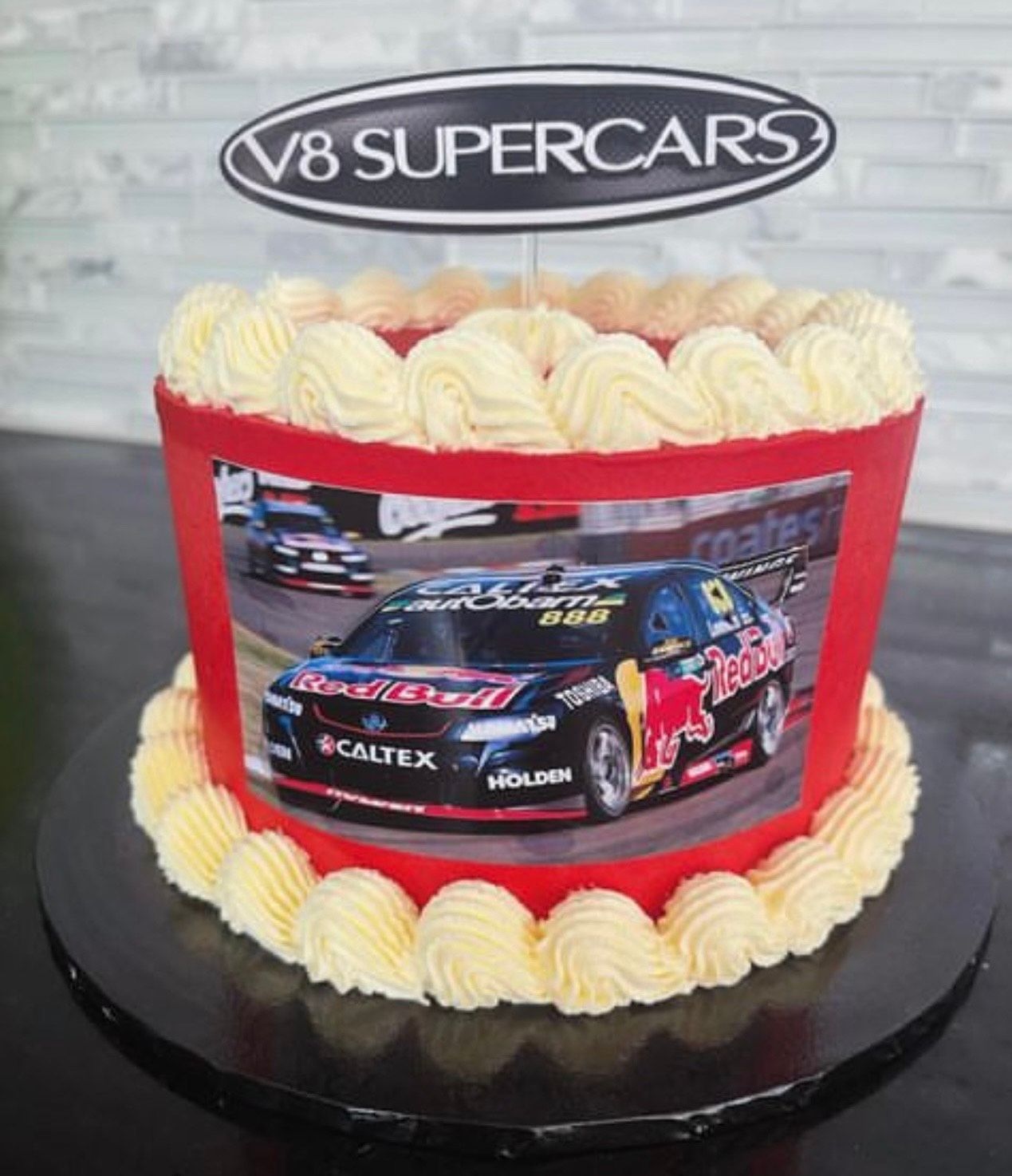 A cake with a picture of a race car and the words v8 supercars on top