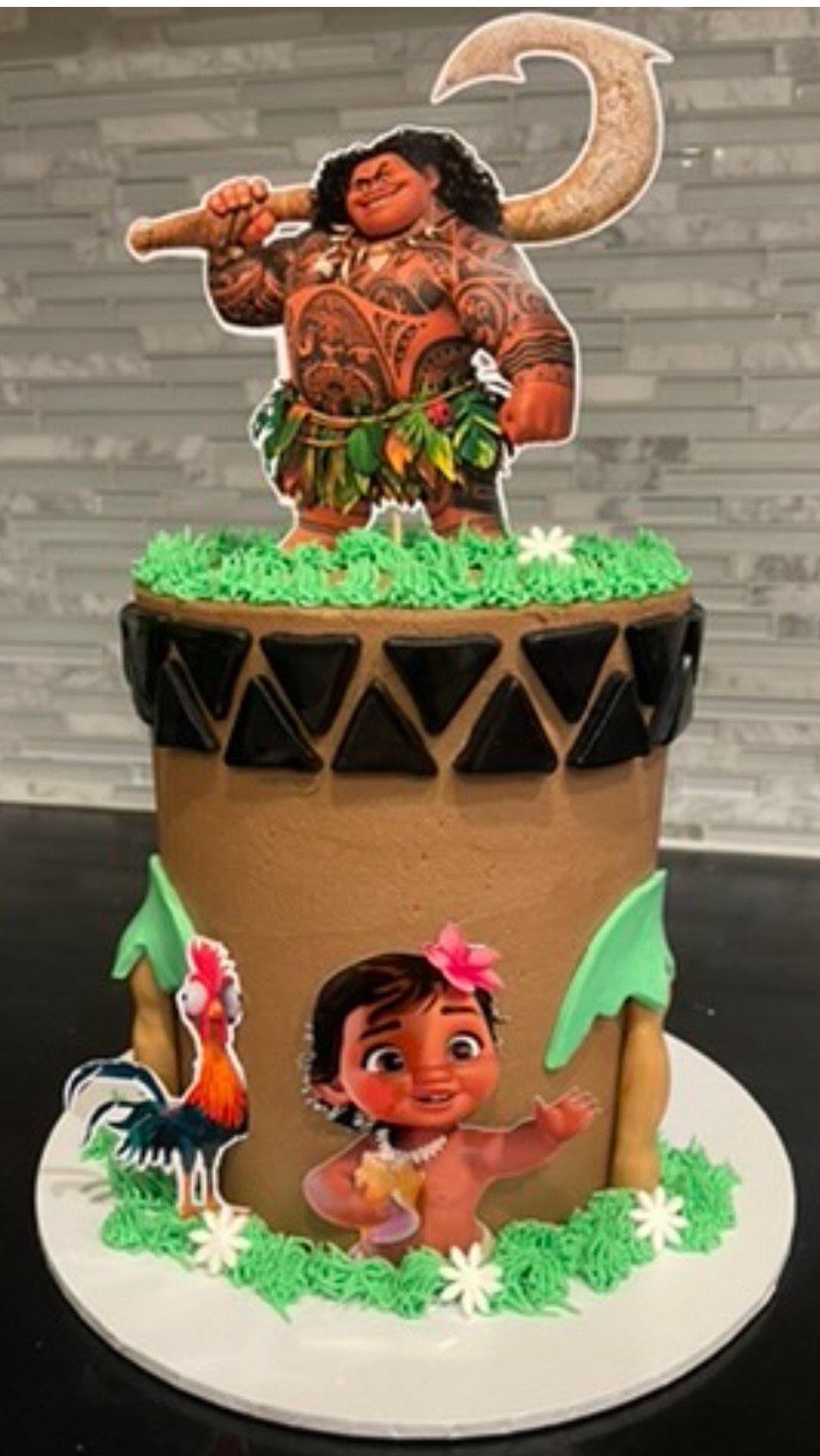 A moana cake with a moana character on top of it.