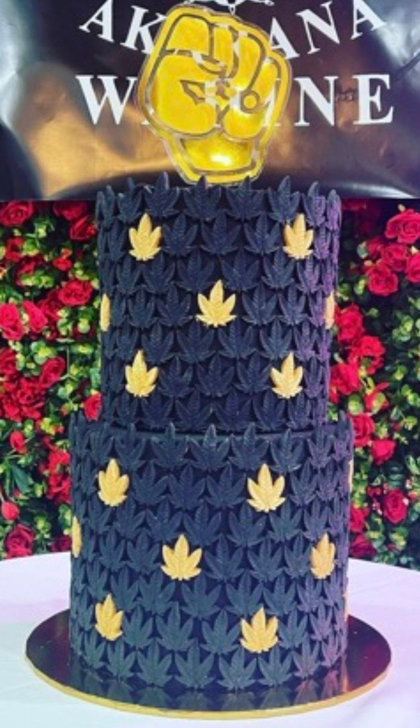 A black and gold cake with leaves on it