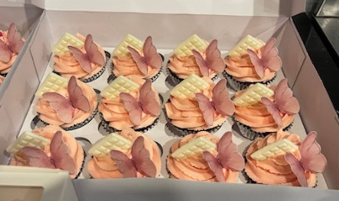 A box of cupcakes with butterflies on them