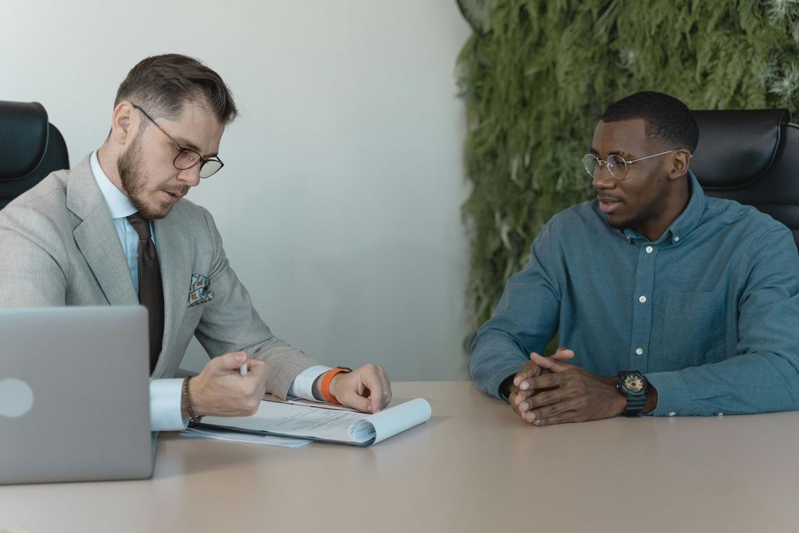 Two men are sitting at a table having a conversation.